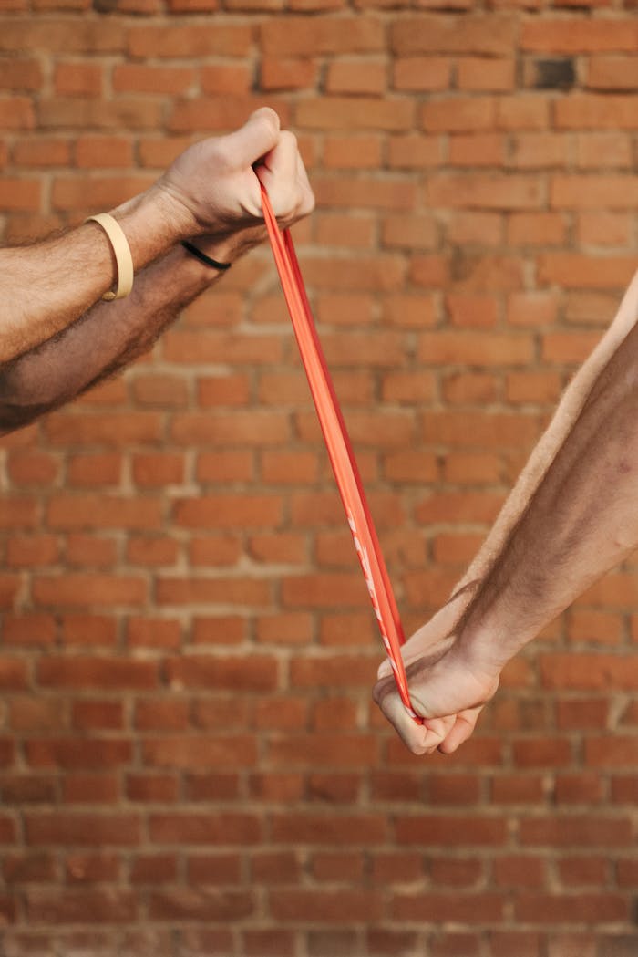 People Working Out Pulling the Resistance Band